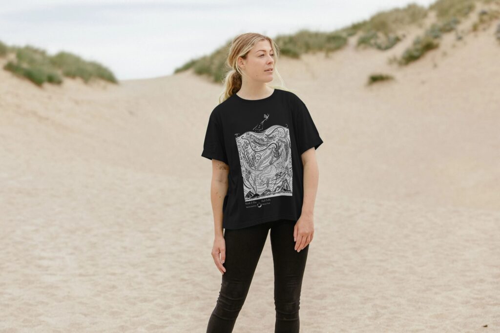 women wearing black tee with white design in sand dunes