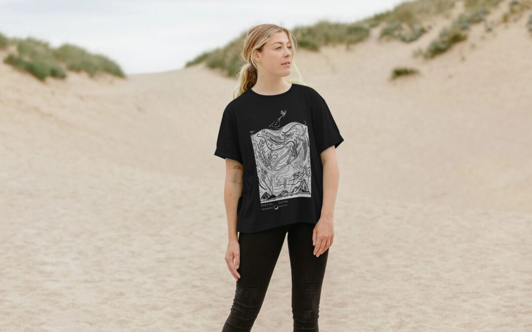 women wearing black tee with white design in sand dunes